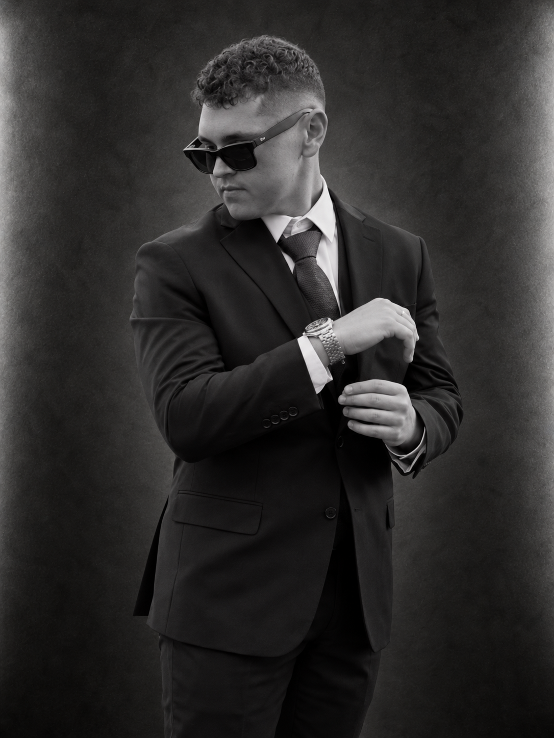 Raydan Jones wearing a suit and sunglasses