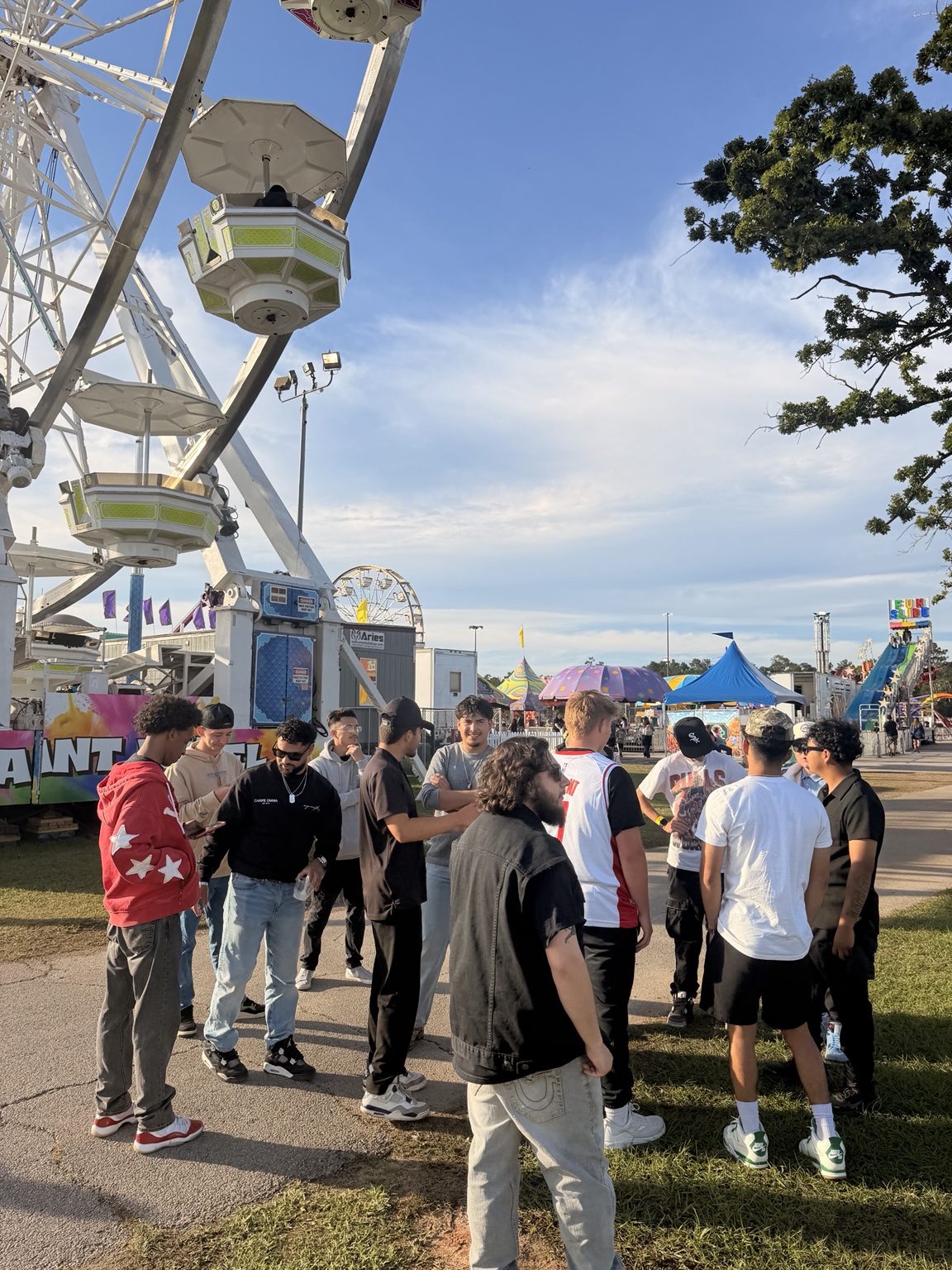 Rally teammates spending time together at a fair beside a Ferris wheel